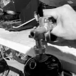 The complete Mr. Heater Fuel Keg refill kit setup showing a 1lb bottle connected to an inverted 20lb propane tank using the official adapter and stabilizing feet.