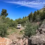 A RV camper parked off-grid in a scenic Idaho meadow, illustrating how to stay cool while boondocking.