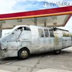 Custom built RV that looks like an airplane fuselage parked in the Arizona desert.