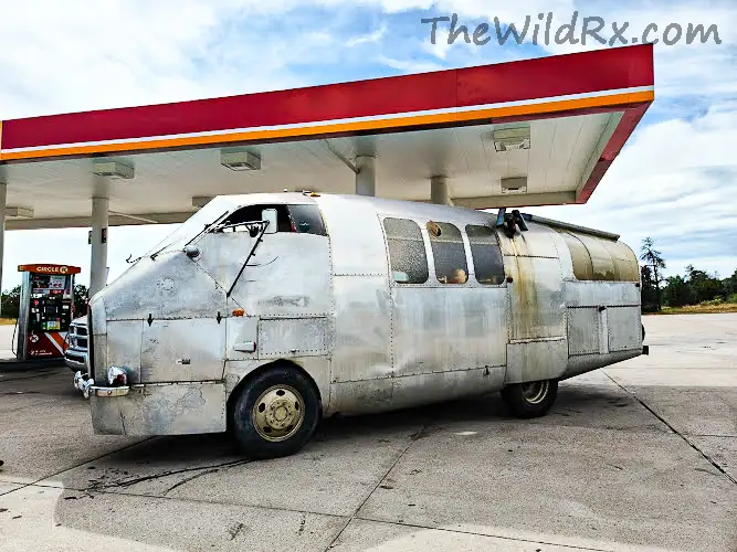 Custom built RV that looks like an airplane fuselage parked in the Arizona desert.