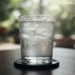 Close-up of a glass of fresh water with condensation drops, illustrating the dew point extraction process of an AWG.