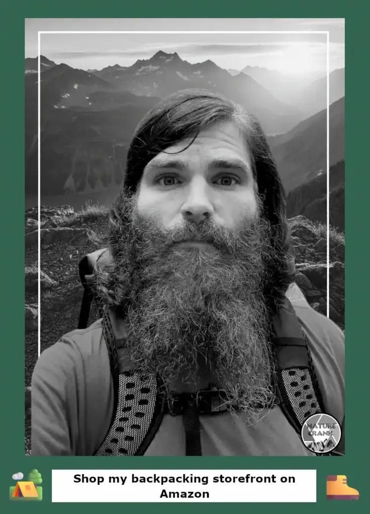 ortrait of a bearded backpacker with a mountain wilderness background.