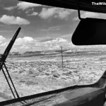View from an RV windshield overlooking the open desert landscape and mesas in the Southwest US.