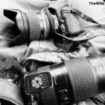 A black and white close-up of a Nikon D810 DSLR camera with a wide-angle lens and a Nikon 70-200mm telephoto lens plus the Nikon D7200.